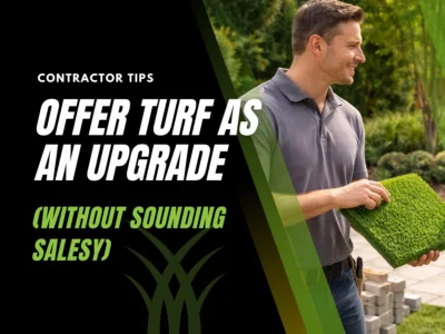 Contractor showing artificial turf sample to homeowners during backyard project consultation.